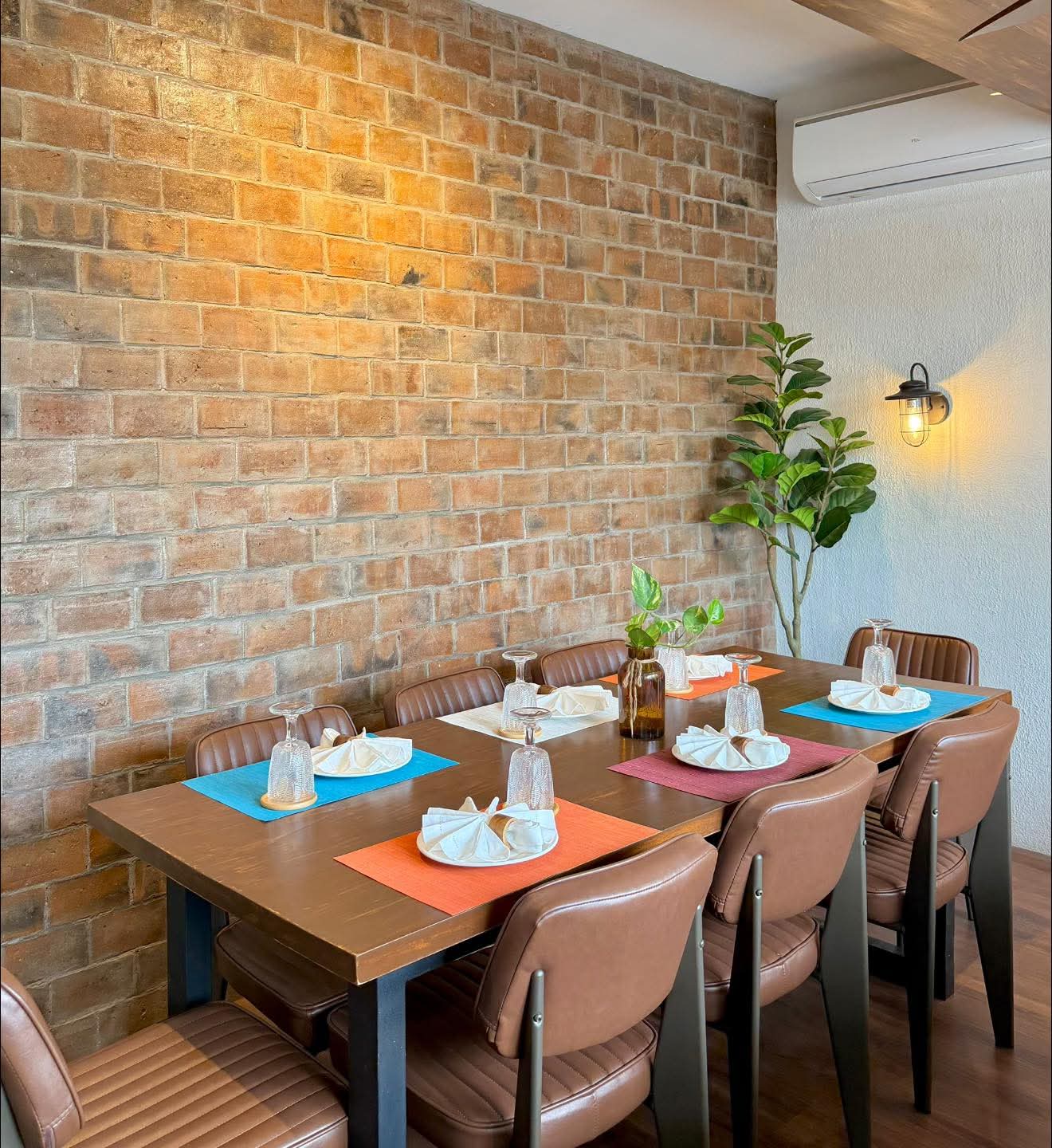 Private dining table beside a warm brick wall