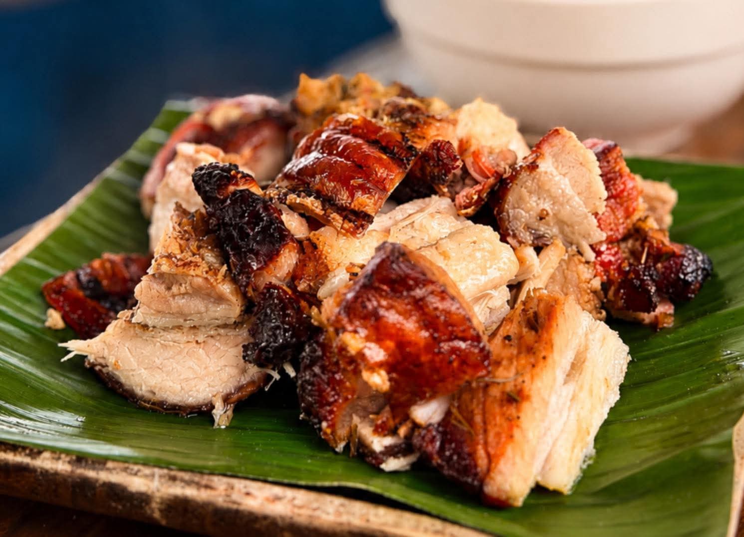 Crisp roasted meat served over banana leaf at Yaelitos