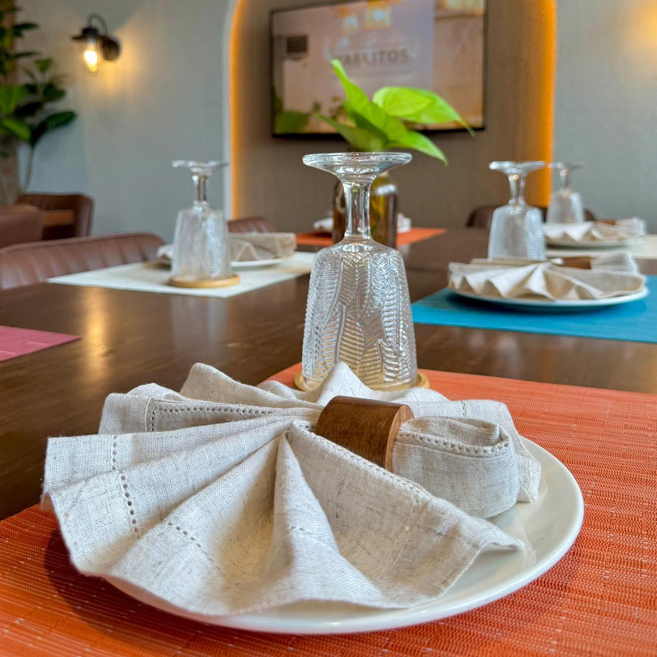 A neatly folded napkin and glass at a prepared Yaelitos table